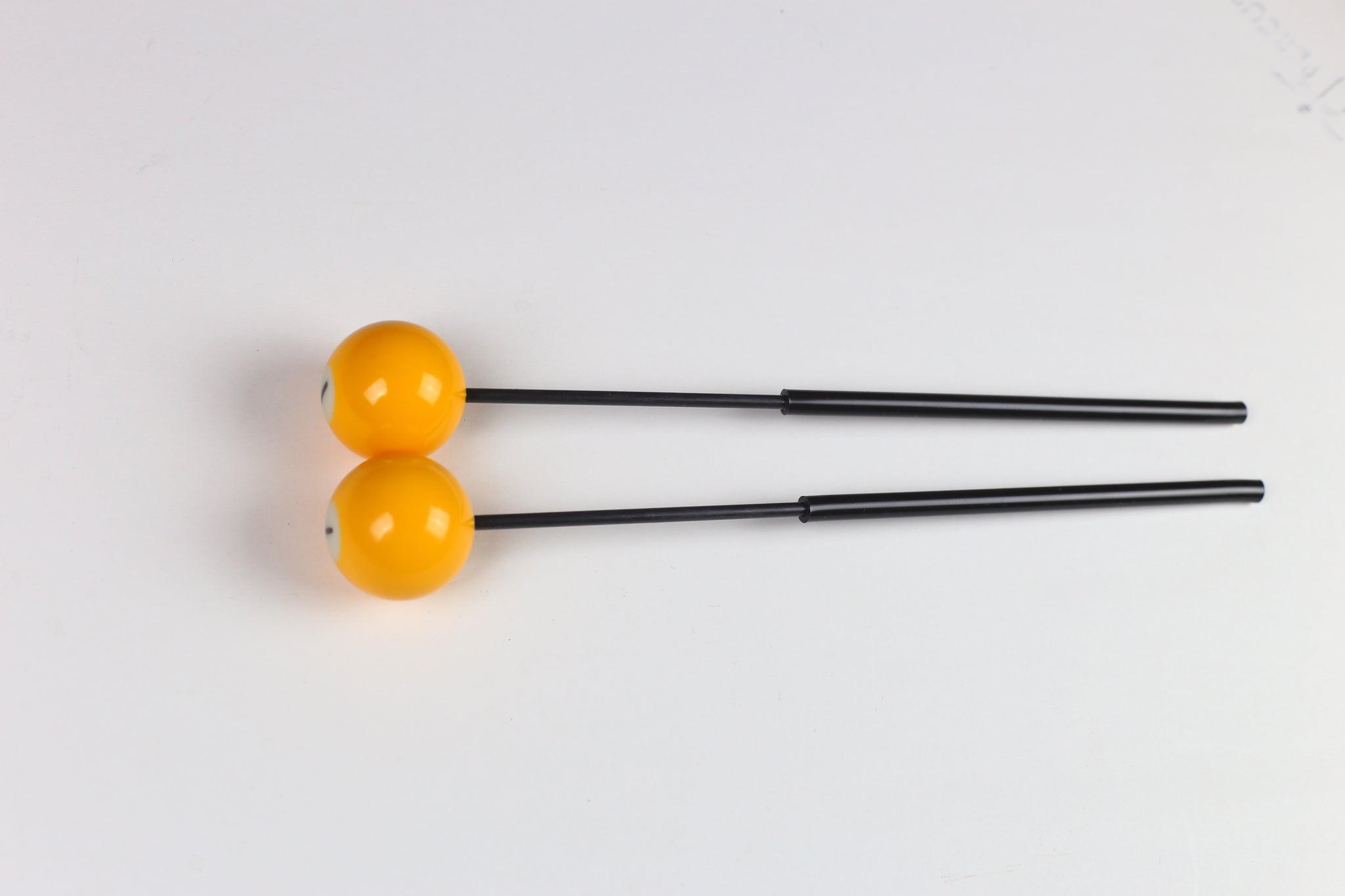 Billiards Ball bell mallets - yellow billiards balls on top of black fiberglass handles with black tubing for grips.