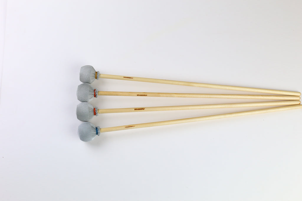 Four marimba mallets lined up in a row with grey heads and different colors of thread wrap.