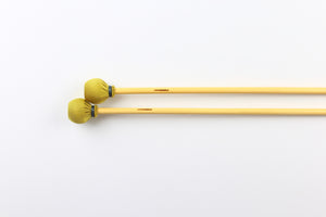 Hard vibraphone mallets with rattan handles and gold spandex wrap.